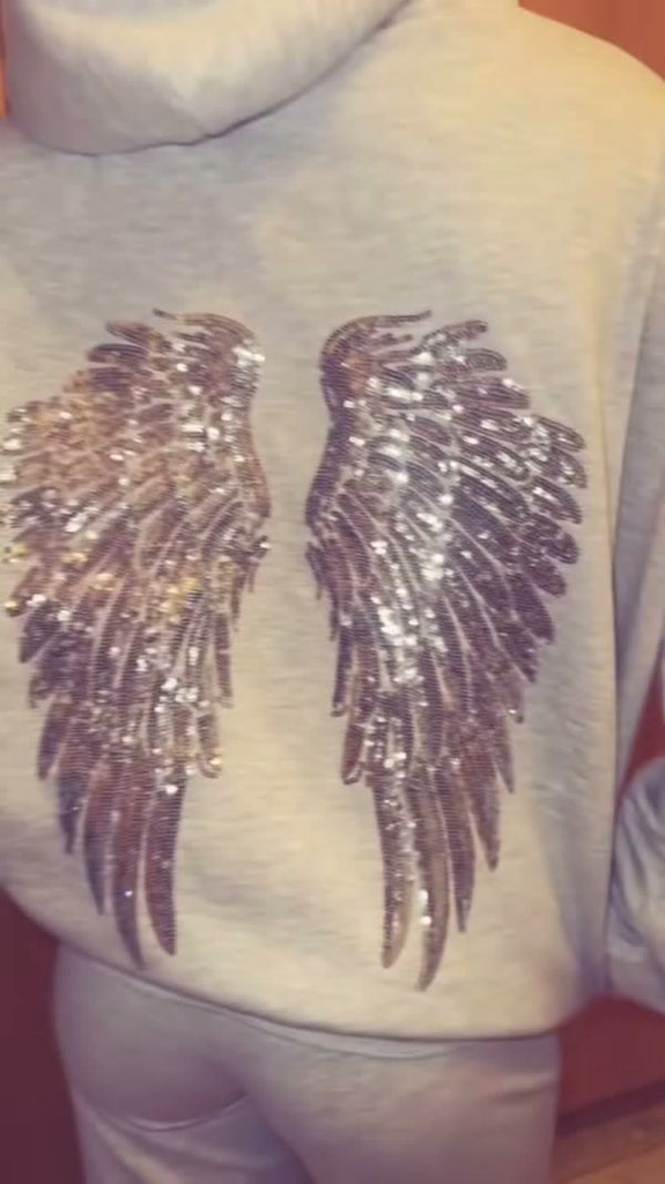 Heist Studio customer wearing the Angel Sequin Hoodie, wings detail