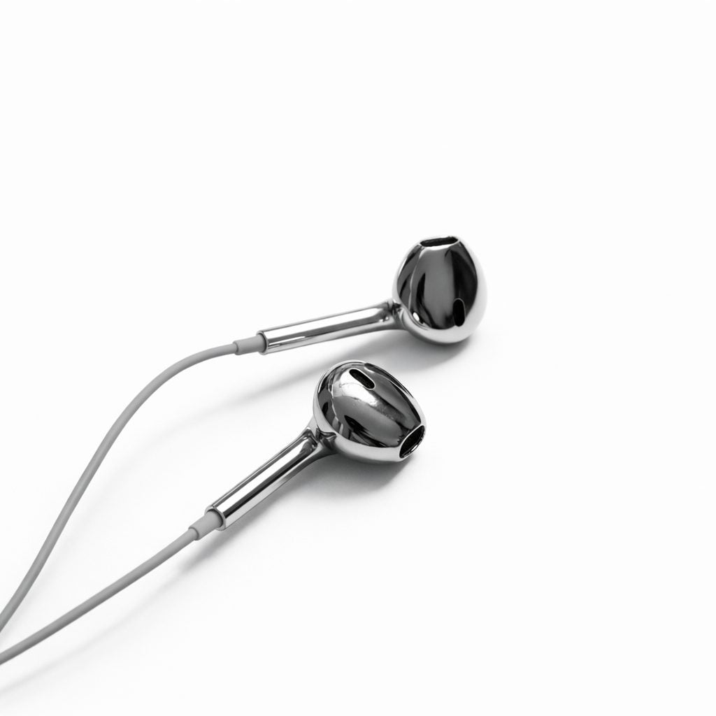 Silver Chrome Buds with the cable looped, flat lay on white