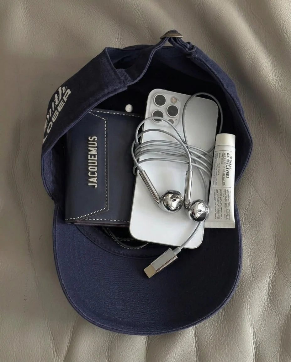 Chrome Buds and a phone in a cap, flat lay
