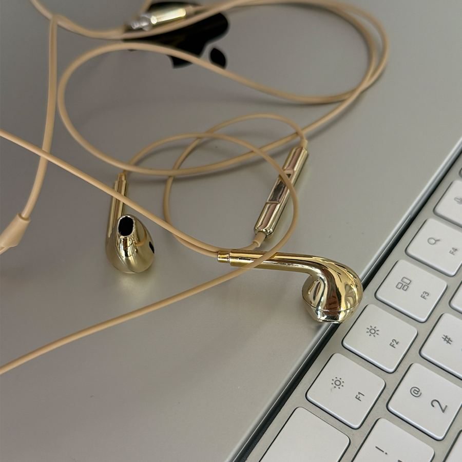 Gold earbuds on a laptop keyboard
