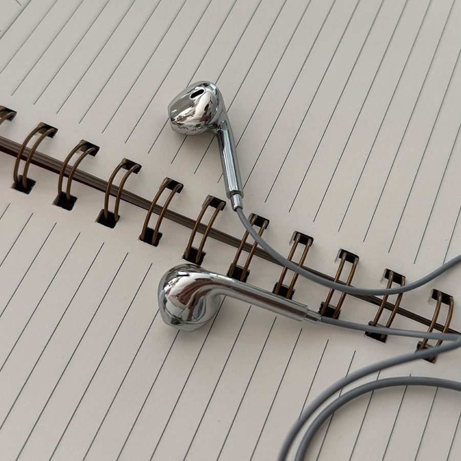 Silver earbuds on a spiral notebook