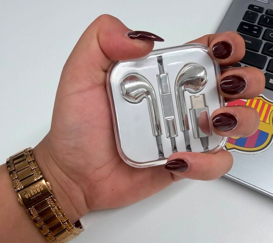 A hand holding the buds in a clear case