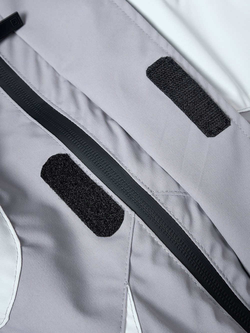 Silver windbreaker, black zip trim and hook-and-loop tabs